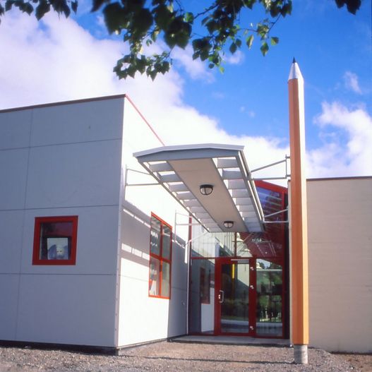 Skolebygg med stor blyant ved inngang
